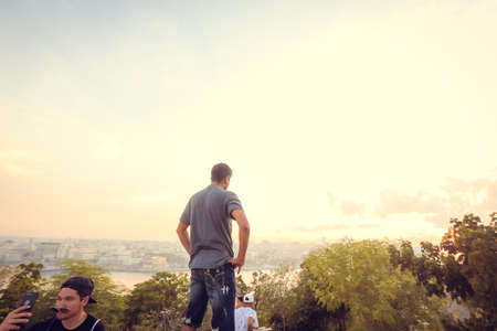 Rear view of a man taking a photo of himself with his smartphone.の写真素材