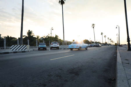 Cars on the road at sunset in the city of Havana, Cuba.の写真素材