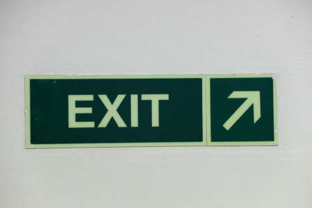 Green emergency exit sign on whiteの写真素材