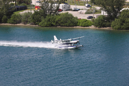 A seaplane landing in the Miami Main channel next to the cruise port of Miami, Florida, USA....