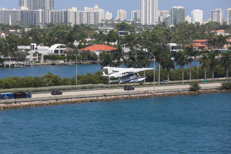 A seaplane landing in the Miami Main channel next to the cruise port of Miami, Florida, USA. Biscayne Bay and cityscape of Miami on the background.のeditorial素材