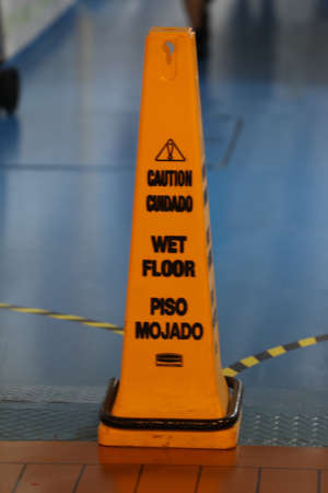 Warning sign for wet floor in airport. Caution wet floor sign