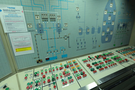 ship engine room dashboard with plenty of bottoms, indicators, small indication lamps and schematics of engines and generators, voltmeters, amperemetersのeditorial素材