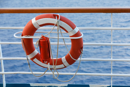 Lifebuoy or life ring orange on the ship with backdrop of the sea landscape. Safety equipment. High quality stock photo image of obligatory ship equipment, personal flotation device prevent drowningの写真素材