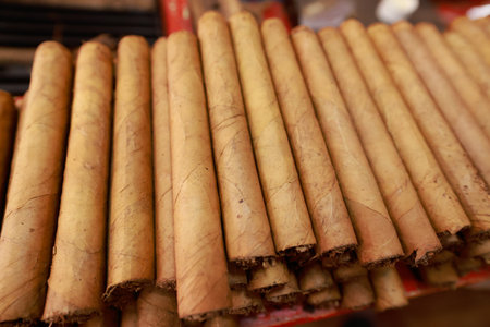 Close up of luxury hand made cigars stacked in a storage box. Tobacco display background or wall art.の写真素材