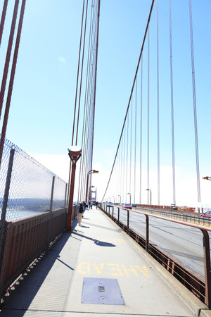 bright red column of Golden Gate Bridge against blue sky.