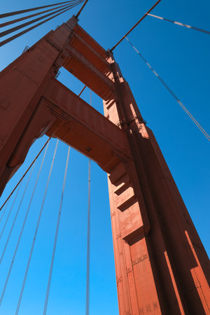 bright red column of Golden Gate Bridge against blue sky.