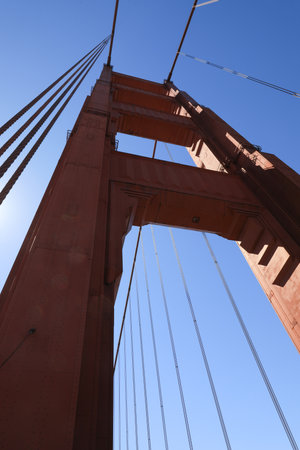 bright red column of Golden Gate Bridge against blue sky.