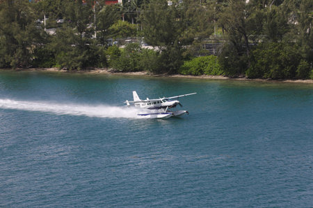 A seaplane landing in the Miami Main channel next to the cruise port of Miami, Florida, USA....