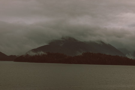 Cruise ship at a port in Juneau, Alaska with snow capped mountain and low lying fog in the backgroundの写真素材