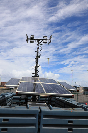 Modern light support with a lantern and installed solar panels on a blue sky background.