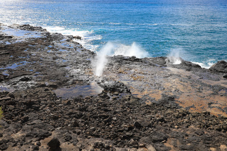 Spouting Horn is off the southern coast of Kauai in the Koloa district and is known for its crashing waves and large sprays of water.の写真素材