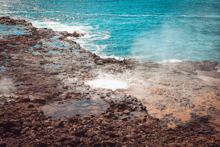 Spouting Horn is off the southern coast of Kauai in the Koloa district and is known for its crashing waves and large sprays of water.の写真素材