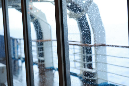 Cruise ship Open deck with Rescue Lifeboats and life buoy through the Window in raindropsの写真素材