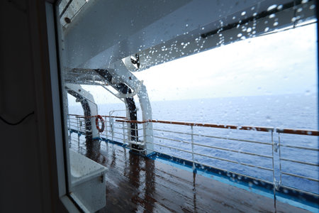 Cruise ship Open deck with Rescue Lifeboats and life buoy through the Window in raindropsの写真素材