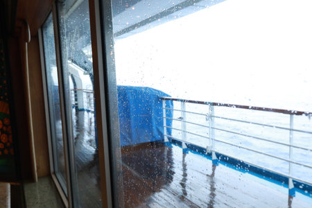 Cruise ship Open deck with Rescue Lifeboats and life buoy through the Window in raindrops