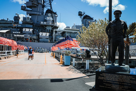 HONOLULU, OAHU, HAWAII, USA - September 22, 2024: bronze statue of Admiral Chester W. Nimitz at battleship USS Missouri in Pearl Harbor Memorial with American flags. Commander in chief of Pacific Fleet.のeditorial素材