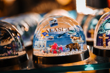 Close-up of an Alaska Souvenir Snow Globe Featuring Wildlife and Nature Icons in a Gift Shop