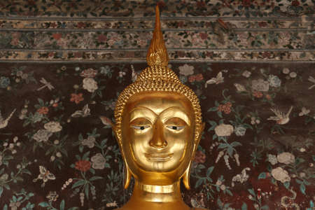 Buddha gold statue in front off old wallの写真素材
