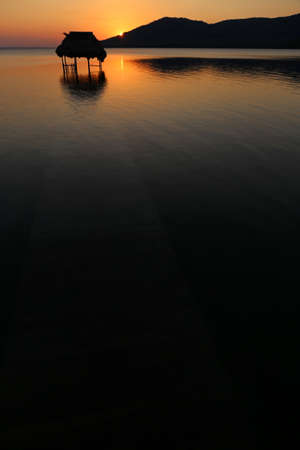 Overwater Hut and Sunset - Lake Peten Itza in Guatemalaの写真素材