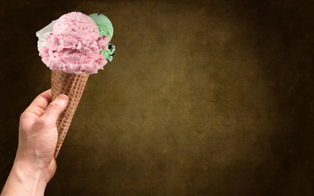 Left hand with ice cream on the dark background
