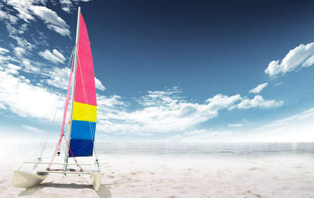 Sailing boat on the beach with sea and sky with clouds in the backgroundの写真素材
