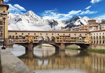 Florence, Italy: Ponte Vecchio, Old Bridge, with Arno river and mountains in the backgroundの写真素材