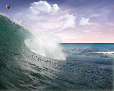 Wave in the Atlantic Ocean with hot air balloon flying in the sky at the sunrise