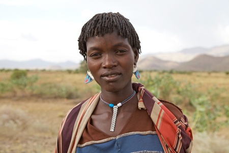Jinka, Ethiopia, Febrauary 13, 2013: african woman, of the Samai ethnic group, with tribal tattoo on the face is going to the villageのeditorial素材
