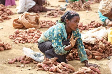 Dorze village, Ethiopia, February 21, 2013: african woman of the Dorze ethnic group are selling potatos at the Dorze village market.のeditorial素材