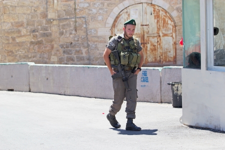 Israeli soldier with assault rifle at the check point between jewish territory and palestinian territory in Hebronのeditorial素材