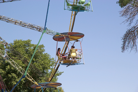 Uzbek people on the vintage panoramic wheel at the Luna Park near the historic centre of Bukhara, Uzbekistan. Bukhara is a city museum with over 140 architectural monuments. The historic centre of Bukhara, which contains numerous mosques and madrassas, haのeditorial素材
