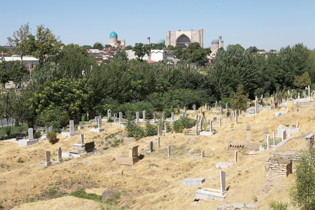 Graves at the Shah-i-Zinda with Registan in the background, Samarkand, Uzbekistan. Shah-i-Zinda is a necropolis in the north-eastern part of Samarkand. It includes mausoleums and other ritual buildings of 9-14th and 19th centuries. Shah-i-Zinda,meaning Thのeditorial素材