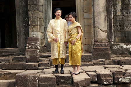 cambodian tourists in traditional cloths are visiting the Bayon temple, Angkor, Siem Reap, Cambodia. Bayon is a richley decorated Khmer temple at Angkor. It was built in late 12th and early 13th centuries. Bayon stands at the centre of the Angkot Thom, thのeditorial素材