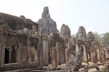 Tourists are visiting the Bayon temple, Angkor, Siem Reap, Cambodia. Bayon is a richley decorated Khmer temple at Angkor. It was built in late 12th and early 13th centuries. Bayon stands at the centre of the Angkot Thom, the capital of the Khmer Empireのeditorial素材