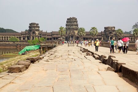 Tourist are walking along the causeway to Angkor Wat, Angkor, Siem Reap, Cambodia. Angkor Wat was first a Hindu later a Buddhist temple complex and the largest religious monument in the world.のeditorial素材