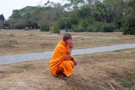 Buddhist monk is phoning using mobile phone at Angkor Wat, Siem Reap, Cambodiaのeditorial素材