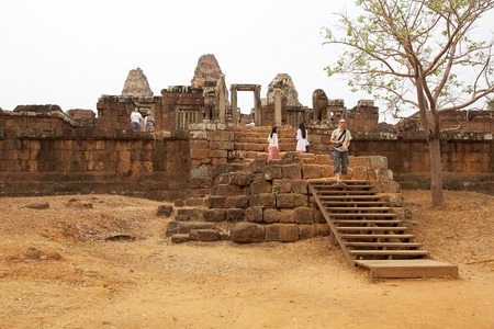 Tourists are visiting the East Mebon temple ruins, Angkor, Siem Reap, Cambodia. East Mebon temple was built in the second half of 10th century. Built in the general style of Pre Rup, East Mebon has two enclosing and three tiers.の写真素材