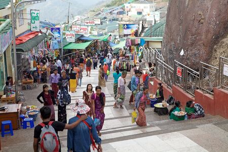 Pilgrims and tourists are walking along the street near the Golden Rock Pagoda Kyaiktiyo Kyaiktiyo Myanmar or Burma. Kyaiktiyo Pagoda anche known as Golden Rock is a well known Buddhist pilgrimage site in the Mon State Myanmar.のeditorial素材