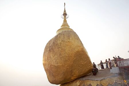 Pilgrims are praying and pasting gold leaves at the Kyaiktiyo Pagoda Golden Rock Kyaiktiyo Myanmar...