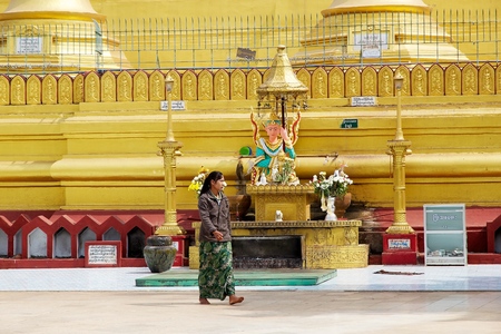 Burmese woman is walking in the Shwemawdaw Paya site Bago Myanmar. Shwemawdaw Paya is a stupa located in Bago Myanmar. It is often referred to as the Golden God Temple. At 114 m in height it is the tallest pagoda in Myanmar. The Shwemawdaw Paya was built のeditorial素材