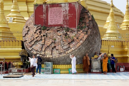 Pilgrims are visiting the sacred hti, the ornament that tops the pagoda, collapsed during the earthquake in 1917 at the Shwemawdaw Paya, Bago, Myanmar. Shwemawdaw Paya is a stupa located in Bago, Myanmar. It is often referred to as the Golden God Temple. のeditorial素材