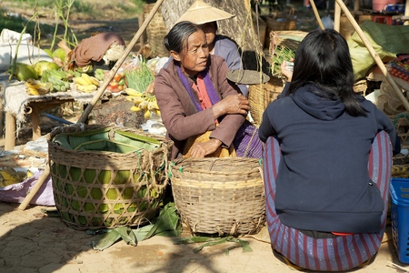Burmese vendor is selling food at the Nan Pan village market on the Lake Inle, Shan State, Myanmarのeditorial素材