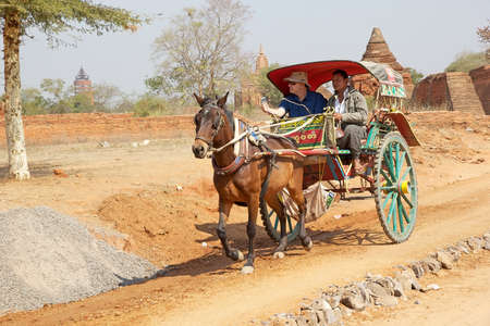 Tourist is visiting the Bagan archaeological site by a wheeled vehicle horse-drawn, Bagan, Myanmarのeditorial素材