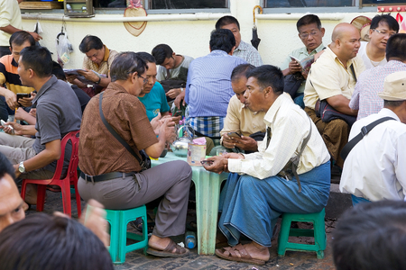 Burmese man are speaking at the bar at the Bogyoke Aung San Market, Yangon, Myanmar. Bogyoke Aung San Market was initially called Scott's Market. It has a great variety of products: jewellery, antiques, handicrafts, clothing, medicine, garments and every のeditorial素材