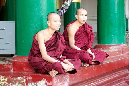 Buddhist monks at the Shwedagon Pagoda, a gilded stupa located in Yangon, Myanmar. The 99 metres tall pagoda is situated on Singuttare Hill, to the West of Kandawgyi Lake and dominates the Yangon skyline. It is the most sacred Buddhist pagoda in Myanmar.のeditorial素材