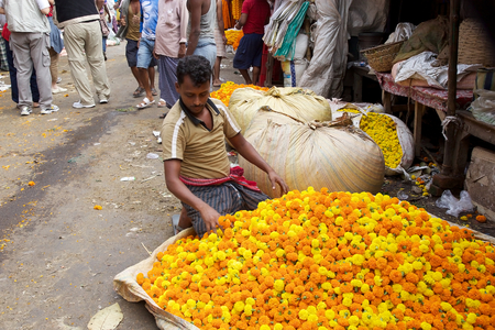 Indian man is selling flowers at the flower market in Kolkata, West Bengal, India. The Mullik Ghat, or Mallik Ghat, is near the southeast end of Howrah Bridge. The flower market is fascinatingly colorful virtually 24 hours a day.のeditorial素材