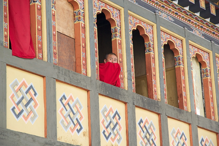 Buddhist monk at the window at the Trashi Chhoe Dzong, Thimphu, Bhutan. Trashi Chhoe Dzong is a Buddhist monastery and fortress on the northern edge of the city of Thimphu. It has traditionally been the seat of the Druk desi, the head of Bhutan's civil goのeditorial素材