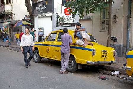 A local taxi driver is sitting on the taxi along the street around Hogg Market. The metered-cabs are mostly of the brand Ambassador manufactured by Hindustan Motors, now out of production.のeditorial素材