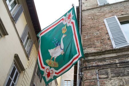 Oca flag at the Oca, goose, contrada border, Siena, Tuscany, Italy. Oca contrada is one of 17 districts in Siena that race in the Palio di Siena. Oca contrada is situated just to the west of Piazza del Campo.の写真素材